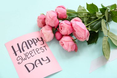 Mesajlı kart Mutlu Tatlı Gün ve mavi arkaplanda güller, yakın plan