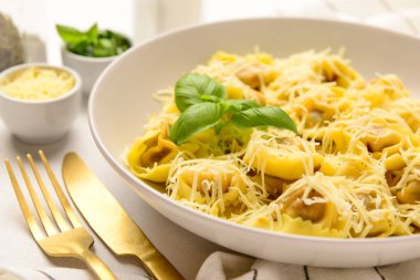 Beyaz arka planda peynirli ve fesleğenli haşlanmış hamur köftesi tabağı, yakın plan.