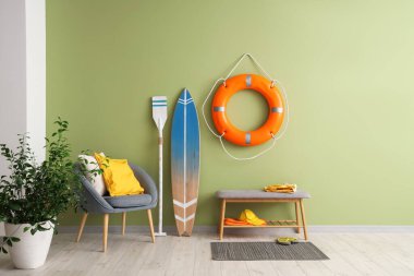 Oturma odasının içinde sörf tahtası, koltuk ve yüzük şamandırası var.