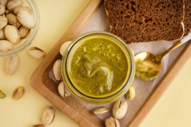 Fıstık ezmeli ahşap tepsi, bej arka planda kaşık ve ekmek