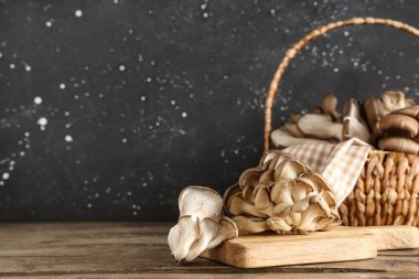 Tahta sepet ve ahşap masada taze istiridye mantarı.