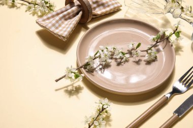 Sarı arka planda çiçek açan dalları olan güzel masa ayarları