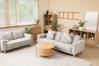 Gri koltukları ve kahve masası olan şık bir oturma odası.