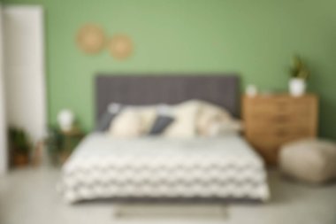 Şık bir yatak odası, komodinli, ahşap çekmeceli, bulanık manzaralı.