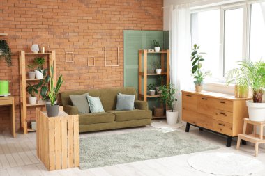 Oturma odasının içinde rahat bir kanepe ve raf ünitesi var.