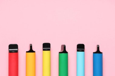 Pembe arka planda farklı elektronik sigaralar.