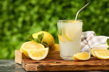 Dışarıdaki siyah masada naneli bir bardak taze limonata.