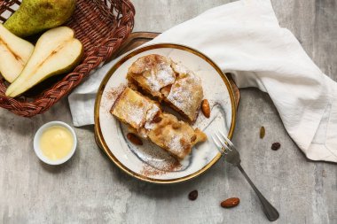 Lezzetli armutlu turta parçaları ve grunge grisi arka planda taze meyve sepeti.