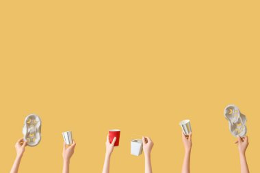 Sarı arka planda çöpleri olan kadın eller. Geri dönüşüm kavramı