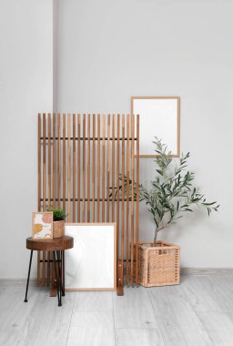 Zeytin ağacı, sehpa, resim ve katlanır ekran olan bir oturma odası.