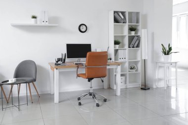 Çalışma yeri, modern bilgisayar, dizüstü bilgisayar ve koltuklu hafif ofisin şık iç tasarımı