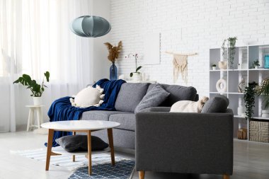 Yumuşak kanepesi, koltuğu ve sehpası olan şık bir oturma odası.