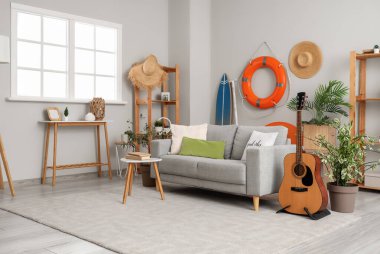 Kanepesi, gitarı ve can simidi olan modern oturma odasının içinde.