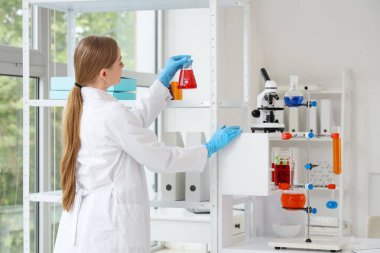 Laboratuvarda matarası olan kadın kimyager.