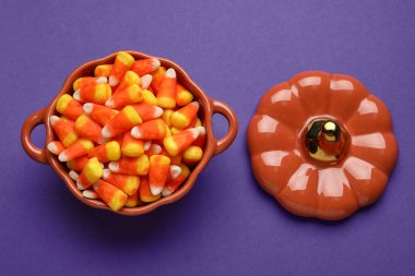 Mor arka planda lezzetli Cadılar Bayramı şekerleri seramik demlik