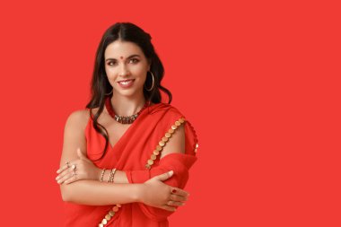 Kırmızı arka planda geleneksel sarili güzel bir Hintli kadın. Divaly kutlaması