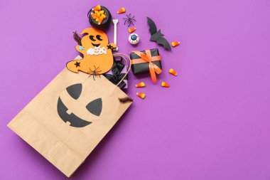 Renkli arkaplanda Cadılar Bayramı için alışveriş torbası, hediye, süs ve tatlı kompozisyonu