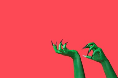 Kırmızı arka planda cadının yeşil elleri. Cadılar Bayramı