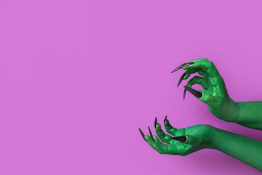 Mor arka planda cadının yeşil elleri. Cadılar Bayramı