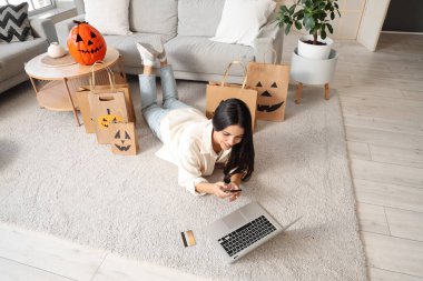 Cadılar Bayramı için cep telefonu alışverişi yapan genç bir kadın.