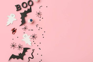 Pembe arka planda Cadılar Bayramı için farklı dekorasyonlara sahip kompozisyon