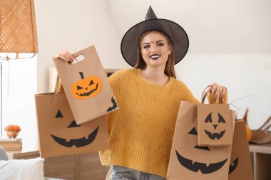 Cadı şapkalı, alışveriş çantalı genç bir kadın. Cadılar Bayramı