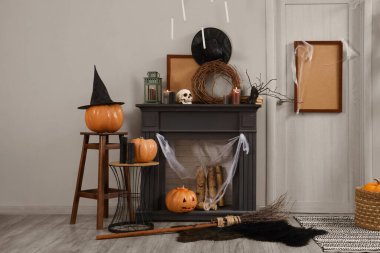 Koridorun içi Cadılar Bayramı için kapı, balkabağı ve şömine raflarıyla süslenmiş.