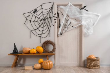 Koridorun içi Cadılar Bayramı için kapı, bank ve balkabaklarıyla süslenmiş.