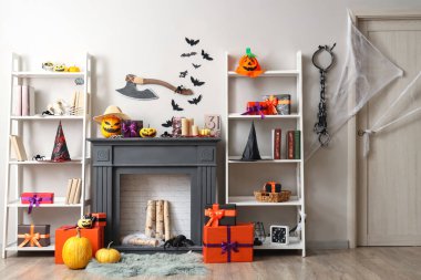 Koridorun içinde Cadılar Bayramı süslemeleri olan şömine ve raflar.