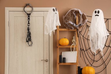 Cadılar Bayramı için salon kapısı ve raf ünitesi ile dekore edilmiş.