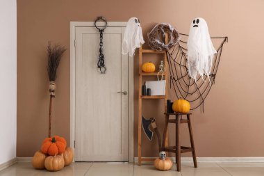 Cadılar Bayramı için salon kapısı ve raf ünitesi ile dekore edilmiş.