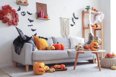 Cadılar Bayramı için dekore edilmiş oturma odasının içi kanepe, masa ve balkabaklarıyla dolu.