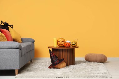 İçinde kanepe ve Cadılar Bayramı balkabakları olan bir oturma odası.