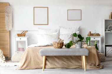 Yatak odasının içinde rahat bir yatak odası ve yatağın yanında kitaplar var.