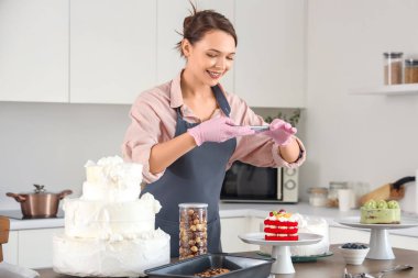 Kadın pastacı mutfakta kek fotoğrafı çekiyor.