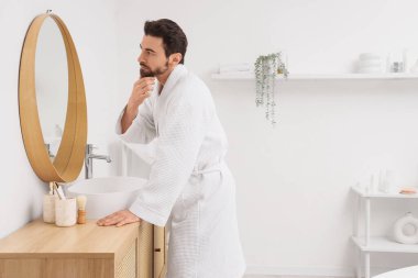 Banyoda aynanın yanında yakışıklı bir adamın sabahı.