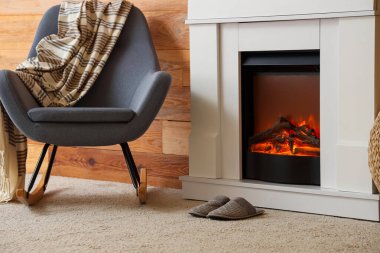 Şöminesi, koltuğu ve terlikleri olan bir oturma odası.