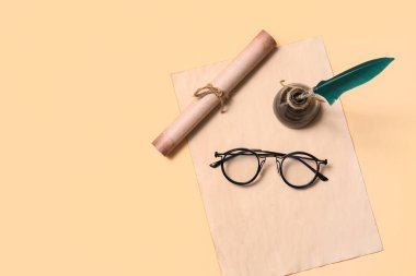 Bej arka planda kalem, mürekkep, kaydırma ve gözlüklü eski kağıt çarşaf