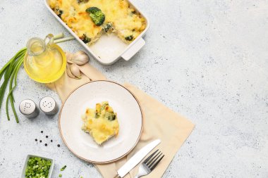 Brokolili fırında makarna, yeşil soğan, sarımsak ve hafif arka planda bir sürahi yağ.