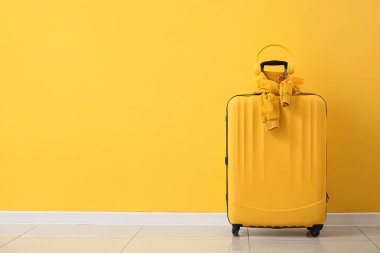 Odada sarı duvarın yanında kulaklıklı, gözlüklü ve kazaklı çanta.