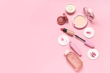 Pembe arka planda kirli pamuk pedleri ve farklı kozmetik ürünleri olan kompozisyon