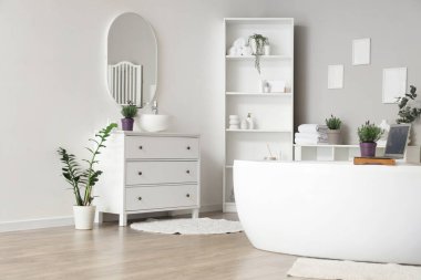 İçinde lavanta çiçekleri olan modern beyaz bir banyo.