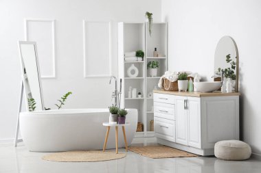 İçinde lavanta çiçekleri olan modern beyaz bir banyo.