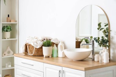 Modern banyoda lavabonun yanında lavanta çiçekleri olan tencere.