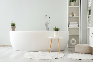 İçinde lavanta çiçekleri olan modern beyaz bir banyo.