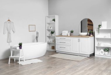 İçinde lavanta çiçekleri olan modern beyaz bir banyo.