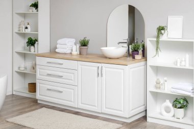 Modern banyoda lavabosu, aynası ve lavanta çiçekleri olan raf ünitesi