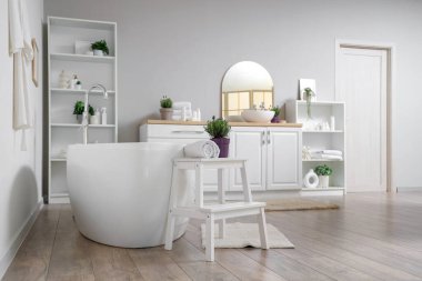 İçinde lavanta çiçekleri olan modern beyaz bir banyo.