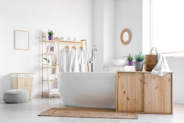 İçinde lavanta çiçekleri olan modern beyaz bir banyo.