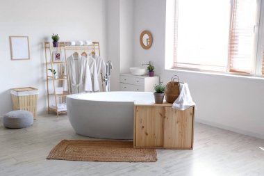 İçinde lavanta çiçekleri olan modern beyaz bir banyo.